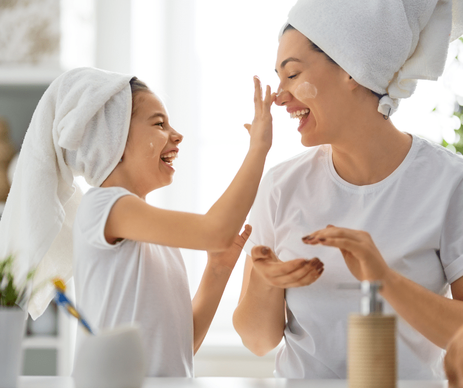 Mom and daughter doing skincare together wearing white robes.